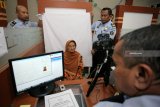 Petugas Imigrasi melayani perekaman paspor  Jamaah Calon Haji Indonesia (JCHI) yang sedang sakit di Kantor Imigrasi Kelas II Non TPI Blitar, Jawa Timur, Selasa (12/2/2019). Divisi Imigrasi Jawa Timur mempersiapkan sembilan Kantor Imigrasi untuk memproses dokumen keimigrasian bagi sebanyak 35.034 JCHI asal propinsi tersebut yang sudah dimulai sejak awal Februari, dan ditargetkan rampung pada April mendatang. Antara Jatim/Irfan Anshori/ZK