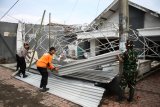 Personel TNI-Polri membantu memperbaiki rumah warga yang terdampak angin puting beliung di Desa Randegan, Tanggulangin, Sidoarjo, Jawa Timur, Kamis (14/2/2019). Puluhan rumah di wilayah tersebut mengalami kerusakan akibat diterjang angin puting beliung yang terjadi pada hari Rabu (13/2/2019) petang. Antara Jatim/Umarul Faruq/zk