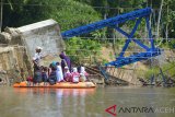 Warga menggunakan perahu karet menyeberangkan murid sekolah melintasi sungai di lokasi ambruknya jembatan gantung diterjang banjir bandang di desa Siron, Kecamatan Kuta Cot Glie, KabupatenAceh Besar, Kamis (14/2/2019). Kementerian Pekerjaan Umum dan Perumahan Rakyat (PUPR) tahun 2019, akan membangun jembatan gantung baru sebanyak 166 unit di seluruh pelosok tanah air dan sembilan unit di antaranya berada di Aceh. (Antara Aceh/Ampelsa)