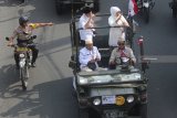 Gubernur Jawa Timur Khofifah Indar Parawansa (kanan) bersama Wakil Gubernur Jawa Timur Emil Elestianto Dardak (kiri) menyapa warga dari atas mobil Jeep kuno saat berparade di Jalan Wonokromo, Surabaya, Jawa Timur, Kamis (14/2/2019). Parade yang diikuti 99 mobil Jeep tersebut untuk menyambut kedatangan Gubernur dan Wakil Gubernur Jawa Timur yang baru Khofifah Indar Parawansa dan Emil Elestianto Dardak. Antara Jatim/Moch Asim/ZK.