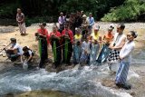 Sejumlah seniman, budayawan dan warga melakukan ritual Bhakti Tirta Bumi atau Ngiwak di sungai Sileng Desa Jowahan, Borobudur, Magelang, Jawa Tengah, Kamis (14/2/2019). Kegiatan bernuansa budaya tradisional yang diakhiri dengan melepas ribuan ekor bibit ikan tersebut sebagai bentuk kepedulian terhadap kelestarian lingkungan dan perlindungan alam. (ANTARA FOTO)