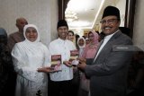 Mantan Wakil Gubenur Jawa Timur Saifullah Yusuf (kanan) menyerahkan buku 