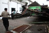 Personel TNI-Polri membantu memperbaiki rumah warga yang terdampak angin puting beliung di Desa Randegan, Tanggulangin, Sidoarjo, Jawa Timur, Kamis (14/2/2019). Puluhan rumah di wilayah tersebut mengalami kerusakan akibat diterjang angin puting beliung yang terjadi pada hari Rabu (13/2/2019) petang. (ANTARA FOTO)