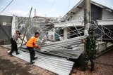 Personel TNI-Polri membantu memperbaiki rumah warga yang terdampak angin puting beliung di Desa Randegan, Tanggulangin, Sidoarjo, Jawa Timur, Kamis (14/2/2019). Puluhan rumah di wilayah tersebut mengalami kerusakan akibat diterjang angin puting beliung yang terjadi pada hari Rabu (13/2/2019) petang. (ANTARA FOTO)