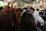 Menteri BUMN Rini Soemarno (kanan) berdialog dengan sejumlah murid di tempat wisata edukasi peternakan sapi perah dan kambing etawa yang merupakan CSR BNI  ketika kunjungan progaram Perhutanan Sosial di Dusun Karang Anyar, Lumajang, Jawa Timur, Jumat (15/2/2019). Sejak program Perhutanan Sosial dan KUR BNI menyentuh desa tersebut   tercatat ada pertumbuhan yakni jumlah sapi meningkat dari 400 ekor menjadi 882 ekor sehinga produksinya pun meningkat menjadi sedikitnya 5.000 liter per hari dan jumlah ternak kambing tumbuh dari 8.000 menjadi 11.000 ekor.    Antara Jatim/Zabur Karuru