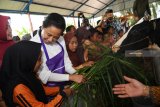 Menteri BUMN Rini Soemarno (kedua kiri) bersama sejumlah murid memberi makan sapi perah yang terdapat di tempat wisata edukasi peternakan sapi perah dan kambing etawa yang merupakan CSR BNI  ketika kunjungan progaram Perhutanan Sosial di Dusun Karang Anyar, Lumajang, Jawa Timur, Jumat (15/2/2019). Sejak program Perhutanan Sosial dan KUR BNI menyentuh desa tersebut   tercatat ada pertumbuhan yakni jumlah sapi meningkat dari 400 ekor menjadi 882 ekor sehinga produksinya pun meningkat menjadi sedikitnya 5.000 liter per hari dan jumlah ternak kambing tumbuh dari 8.000 menjadi 11.000 ekor.   Antara Jatim/Zabur Karuru