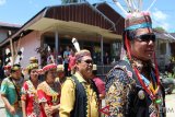 Bupati Mahakam Ulu (depan) saat akan naik ke Lamin Adat Matalibaq untuk mengikuti rangkaian Hudoq Kawit.