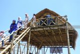 Pengunjung berada dirumah panggung yang terbuat dari bambu di Kampung Wisata Karang Kenek, Desa Olean, Situbondo, Jawa Timur, Minggu (17/2/2019). Kampung Wisata tersebut merupakan kampung wisata di dekat permukiman kecil berisi 26 KK di Desa Olean yang dibangun memakai Dana Desa, bertujuan memajukan desa setempat. Antara Jatim/Seno/ZK.