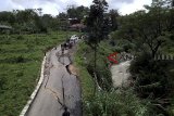 Foto udara jalan yang terbelah akibat pergerakan tanah di jalur wisata, Karang Tengah, Sentul,  Kabupaten Bogor, Jawa Barat, Sabtu (16/2/2019). Pergerakan tanah disebabkan oleh tingginya intesitas hujan di kawasan tersebut, mengakibatkan akses jalan menuju tempat wisata tidak bisa dilantasi oleh kendaraan roda empat karena berbahaya. ANTARA JABAR/Yulius Satria Wijaya/agr.