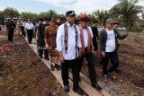 Menteri Perhubungan Budi Karya Sumadi (kiri) bersama Menteri Hukum dan HAM Yasonna Hamonangan Laoly (kedua kiri) berjalan memasuki kawasan lahan pembangunan bandara di Kecamatan Pangmilang, Singkawang Selatan, Kalimantan Barat, Senin (18/2). Pembangunan bandara baru di Kota Singkawang yang akan memiliki landasan pacu ultimate sepanjang 2.500 meter dan mampu menampung pesawat Boeing 737-900 ER tersebut ditargetkan akan selesai pada 2022. ANTARA FOTO/David/jhw