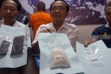 Kepala Badan Narkotika Nasional Kabupaten Tulungagung AKBP Djoko Purnomo (tengah) dan anggota menunjukkan barang bukti narkoba jenis sabu seberat 280 gram berikut tersangka AW yang berperan sebagai kurir di kantor BNNK Tulungagung, Jawa Timur, Rabu (20/2/2019). Di hadapan petugas BNN, tersangka AW mengaku bahwa sabu-sabu senilai Rp392 juta tersebut milik seorang napi berinisial BDK yang kini masih mendekam di LP Narkoba Madiun, dan hendak dijual ke pada seorang pengedar narkoba di Tulungagung yang saat ini masih berstatus buron. Antara Jatim/Destyan Sujarwoko/ZK.
