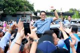 Calon Wakil Presiden nomor urut 02 Sandiaga Salahudin Uno menyapa pendukungnya saat berkunjung di Banyuwangi, Jawa Timur, Kamis (21/2/2019). Kunjungan Sandiaga ke Banyuwangi tersebut, selain bersilaturahmi ke sejumlah pondok pesantren dan mengunjungi petani buah naga, juga berdialog bersama generasi Milenial bertema  