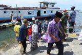 Sejumlah penumpang turun ke perahu sampan dari sebuah perahu motor di Pelabuhan Kalbut, Mangaran, Situbondo, Jawa Timur, Kamis (21/2/2019). Penumpang yang berasal dari Pulau Sapudi, Sumenep tersebut terpaksa menumpang perahu motor yang juga memuat barang dan hewan ternak karena tidak adanya perahu atau kapal khusus penumpang. Antara Jatim/Seno/ZK.