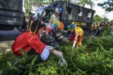 Anggota Polres Tasikmalaya Kota dibantu Komunitas Badut Galeri Tasik (BGT), Pelajar dan Mahasiswa serta Penggiat Lingkungan membersihkan tumpukan sampah yang dibuang sembarangan pada aksi Peringati Sampah Nasional yang dibuang di Pinggir Jalan Kota Tasikmalaya, Jawa Barat, Kamis (21/2/2019). Berdasarkan Kementerian Lingkungan Hidup dan Kehutanan (KLHK) Indonesia masuk dalam peringkat kedua di dunia sebagai penghasil sampah plastik setelah Tiongkok, dengan total jumlah sampah pada 2019 mencapai akan 68 juta ton, dan sampah plastik diperkirakan akan mencapai 9,52 juta ton atau 14 persen dari total sampah yang ada. ANTARA JABAR/Adeng Bustomi/agr.