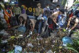 Anggota Polres Tasikmalaya Kota dibantu Komunitas Badut Galeri Tasik (BGT), Pelajar dan Mahasiswa serta Penggiat Lingkungan membersihkan tumpukan sampah yang dibuang sembarangan pada aksi Peringati Sampah Nasional yang dibuang di Pinggir Jalan Kota Tasikmalaya, Jawa Barat, Kamis (21/2/2019). Berdasarkan Kementerian Lingkungan Hidup dan Kehutanan (KLHK) Indonesia masuk dalam peringkat kedua di dunia sebagai penghasil sampah plastik setelah Tiongkok, dengan total jumlah sampah pada 2019 mencapai akan 68 juta ton, dan sampah plastik diperkirakan akan mencapai 9,52 juta ton atau 14 persen dari total sampah yang ada. ANTARA JABAR/Adeng Bustomi/agr.