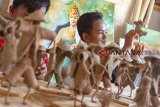 Perajin menyelesaikan pembuatan kerajinan boneka tani berbahan karung goni di Saung Atap Langit, Kampung Tangkolak, Cilamaya Wetan, Karawang, Jawa Barat, Sabtu (23/2/2019). Perajin di saung tersebut mampu membuat 80 sampai 100 boneka per bulan dengan harga jual Rp10 ribu - Rp25 ribu per boneka tergantung dari tingkat kesulitan. ANTARA JABAR/M Ibnu Chazar/agr.