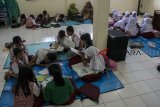 Sejumlah murid SDN Bojong Asih 01 mengungsi belajar akibat banjir di Aula Kantor Desa Dayeuhkolot, Kabupaten Bandung, Jawa Barat, Selasa (26/2/2019). Kegiatan belajar mengajar SDN Bojong Asih 01 dan SDN Bojong Asih 02 tersebut terpaksa mengungsi dan dipindahkan untuk sementara akibat terdampak banjir luapan Sungai Citarum serta intensitas curah hujan yang tinggi. ANTARA JABAR/Novrian Arbi/agr.