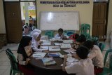 Sejumlah murid SDN Bojong Asih 01 mengungsi belajar akibat banjir di Aula Kantor Desa Dayeuhkolot, Kabupaten Bandung, Jawa Barat, Selasa (26/2/2019). Kegiatan belajar mengajar SDN Bojong Asih 01 dan SDN Bojong Asih 02 tersebut terpaksa mengungsi dan dipindahkan untuk sementara akibat terdampak banjir luapan Sungai Citarum serta intensitas curah hujan yang tinggi. ANTARA JABAR/Novrian Arbi/agr.