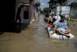 Warga melintasi genangan banjir yang mulai surut di Bojong Asih, Kabupaten Bandung, Jawa Barat, Selasa (26/2/2019). Tiga Kecamatan di Kabupaten Bandung kembali dilanda banjir akibat intensitas curah hujan yang tinggi dan luapan Sungai Citarum. ANTARA JABAR/Novrian Arbi/agr. 