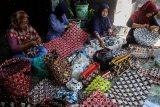 Perajin menyelesaikan pembuatan kerajinan berbahan baku sampah plastik di kawasan Suko, Sidoarjo, Jawa Timur, Selasa (26/2/2019). Kerajinan berbahan sampah plastik yang di daur ulang menjadi tas dan dijual dengan harga Rp25 ribu - Rp250 ribu per buah tersebut kesulitan meningkatkan produksinya karena terkendala modal dan pemasaran. Antara Jatim/Umarul Faruq/zk