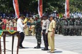 Wakil Gubernur Jawa Timur Emil Elestianto Dardak (kiri) menyerahkan peralatan kerja kepada peserta saat upacara Pembukaan TNI Manunggal Membangun Desa (TMMD) ke-104 tahun 2019 di lapangan Desa Poncol, Kabupaten Magetan, Jawa Timur, Selasa (26/2/2019). Wakil Gubernur Jawa Timur Emil Elestianto Dardak (kedua kiri) menyerahkan bantuan bahan pokok kepada warga seusai upacara Pembukaan TNI Manunggal Membangun Desa (TMMD) ke-104 tahun 2019 di lapangan Desa Poncol, Kabupaten Magetan, Jawa Timur, Selasa (26/2/2019). TMMD ke-104 akan berlangsung selama 30 hari mulai 26 Februari hingga 27 Maret 2019. Antara Jatim/Siswowidodo/ZK.