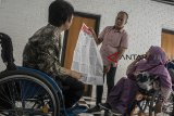 Komisioner KPU Kota Bandung menunjukkan contoh surat suara pada acara Sosialisasi dan Pendidikan Bagi Pemilih Disabillitas pada Pemilu 2019 di Gor Pajajaran, Bandung, Jawa Barat, Rabu (27/2/2019). Kegiatan tersebut bertujuan memberikan pemahaman dan penjelasan tentang akses yang didapat bagi para penyandang disabilitas dalam memberikan hak suara di TPS pada Pemilu 2019 april mendatang. ANTARA JABAR/Novrian Arbi/agr. 