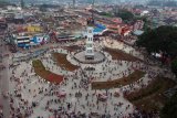 Pengunjung menikmati kawasan pedestrian Jam Gadang, di Bukittinggi, Sumatera Barat, Minggu (24/2/2019). Revitalisasi pedestrian Jam Gadang tersebut rampung dan fasilitasnya kini bisa dinikmati pengunjung serta masyarakat, meliputi kawasan ramah disabilitas, taman bunga, lampu hias, dan air mancur. ANTARA FOTO/Iggoy el Fitra/aww.