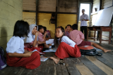 Sejumlah siswa SDN 08 duduk di lantai saat belajar di bangunan bekas rumah guru di kawasan perbatasan Indonesia-Malaysia di Desa Bungkang, Kecamatan Sekayam, Kabupaten Sanggau, Kalimantan Barat, Rabu (27/2/2019). Karena kekurangan ruang kelas, sebanyak 42 murid kelas 3 dan 5 SDN 08 terpaksa belajar di bangunan bekas rumah dinas guru yang kondisi atapnya bocor serta lantainya sudah banyak berlubang. ANTARA FOTO/Agus Alfian/jhw

