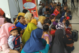 Sejumlah Pekerja Migran Indonesia (PMI) yang dideportasi Pemerintah Malaysia berbaris saat tiba di Pos Lintas Batas Negara (PLBN) Entikong, Kabupaten Sanggau, Kalbar, Rabu (27/2/2019). Pemerintah Malaysia mendeportasi 101 PMI (68 pria dan 33 wanita) beserta 10 anak melalui Depot Imigresen Semunja dan Bekenu (Miri) karena tidak memiliki dokumen resmi. Dua PMI di antaranya mengalami patah kaki akibat kecelakaan kerja dan gangguan jiwa. ANTARA FOTO/Agus Alfian/jhw