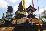 Umat Hindu memasang lembaran kain kuning menjelang upacara Melasti, di Pura Agung Jagat Karana, Surabaya, Jawa Timur, Kamis (28/2/2019).Sejumlah persiapan dilakukan umat Hindu di Surabaya menjelang upacara Melasti pada Minggu (3/3/2019). Antara Jatim/Didik Suhartono/zk