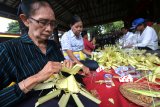 Umat Hindu membuat tempat sesaji dari janur menjelang upacara Melasti, di Pura Agung Jagat Karana, Surabaya, Jawa Timur, Kamis (28/2/2019). Sejumlah persiapan dilakukan umat Hindu di Surabaya menjelang upacara Melasti pada Minggu (3/3/2019). Antara Jatim/Didik Suhartono/zk