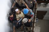 Terdakwa kasus dugaan penganiayaan terhadap remaja Bahar bin Smith (tengah) dikawal petugas seusai menjalani sidang perdana di Pengadilan Negeri Bandung, Jawa Barat, Kamis (28/2/2019). Sidang perdana tersebut dengan agenda pembacaan dakwaan. ANTARA JABAR/M Agung Rajasa/agr.