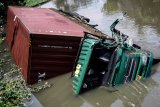 Truk kontainer bermuatan tripleks tercebur ke sungai di kawasan Medaeng, Sidoarjo, Jawa Timur, Kamis (28/2/2019). Truk bernomor Polisi L 9258 UP tersebut menerobos pembatas jalan dan diduga pengemudi mengantuk. Antara Jatim/Umarul Faruq/zk