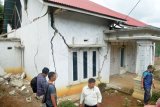 Sejumlah warga memperhatikan rumah yang rusak akibat gempa di Kabupaten Solok Selatan, Sumatera Barat, Kamis (28/2/2019). Data sementara Badan Penanggulangan Bencana Daerah (BPBD) Sumatera Barat, 48 warga luka-luka, 329 rumah rusak serta sejumlah fasilitas umum rusak akibat gempa tektonik berkekuatan 5.6 SR yang berpusat di Kabupaten Solok Selatan. (ANTARA FOTO)