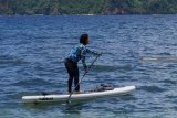 Menteri Kelautan dan Perikanan Susi Pudjiastuti (kanan) bermain kayak di Pantai Mutiara, Trenggalek, Jawa Timur, Senin (4/2). Aktivitas santai itu dilakukan di sela kunjungan kerjanya meninjau Pelabuhan Perikanan Nusantara Prigi dan bertemu nelayan setempat. Antara Jatim/Destyan Sujarwoko/ZK