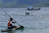 Menteri Kelautan dan Perikanan Susi Pudjiastuti (tengah) ditemani Wakil Bupati Trenggalek Moch Nur Arifin (kiri) bermain kayak di Pantai Mutiara, Trenggalek, Jawa Timur, Senin (4/2). Aktivitas santai itu dilakukan di sela kunjungan kerjanya meninjau Pelabuhan Perikanan Nusantara Prigi dan bertemu nelayan setempat. Antara Jatim/Destyan Sujarwoko/ZK