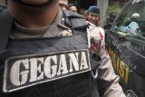 Tersangka kasus penganiayaan anak dibawah umur Bahar Bin Smith (kanan) dikawal polisi setelah dilakukan pelimpahan tahap 2 dari pihak Kepolisian kepada pihak Kejaksaan di Kejaksaan Negeri Cibinong, Bogor, Jawa Barat, Senin (4/2/2019).  Polres Bogor dan Polda Jawa Barat menyatakan berkas Bahar Bin Smith lengkap atau P21. ANTARA JABAR/Yulius Satria Wijaya/agr.