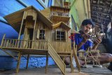 Yoyo Dahyo (27) menyelesaikan pembuatan miniatur rumah adat di Rumah produksinya, Dusun Mandalika, Kabupaten Ciamis, Jawa Barat, Rabu (6/2/2019). Miniatur rumah berbahan limbah bambu bekas bangunan rumah, dijual dengan harga Rp 50 ribu hingga Rp 500 ribu per buah, dengan memproduksi 10-15 miniatur rumah adat serta rumah pohon per bulan yang dipasarkan melalui media daring. ANTARA JABAR/Adeng Bustomi/agr. 