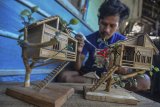 Yoyo Dahyo (27) menyelesaikan pembuatan miniatur rumah adat di Rumah produksinya, Dusun Mandalika, Kabupaten Ciamis, Jawa Barat, Rabu (6/2/2019). Miniatur rumah berbahan limbah bambu bekas bangunan rumah, dijual dengan harga Rp 50 ribu hingga Rp 500 ribu per buah, dengan memproduksi 10-15 miniatur rumah adat serta rumah pohon per bulan yang dipasarkan melalui media daring. ANTARA JABAR/Adeng Bustomi/agr. 