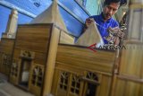 Yoyo Dahyo (27) menyelesaikan pembuatan miniatur rumah adat di Rumah produksinya, Dusun Mandalika, Kabupaten Ciamis, Jawa Barat, Rabu (6/2/2019). Miniatur rumah berbahan limbah bambu bekas bangunan rumah, dijual dengan harga Rp 50 ribu hingga Rp 500 ribu per buah, dengan memproduksi 10-15 miniatur rumah adat serta rumah pohon per bulan yang dipasarkan melalui media daring. ANTARA JABAR/Adeng Bustomi/agr. 