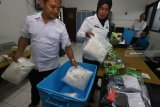 Petugas menata barang bukti narkotika jenis sabu di Badan Narkotika Nasional Provinsi (BNNP) Jawa Timur, Surabaya, Jawa Timur, Senin (4/2/2019). BNNP Jatim menangkap lima orang tersangka berinisial F (36), HSN (33), HSL (49), I (56) serta W S (24) dan mengamankan barang bukti salah satu diantaranya sabu yang diduga dari Malaysia dengan berat sekitar 18,3 kilogram. Antara Jatim/Didik Suhartono/zk