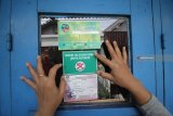 Seorang kader Ibu Memantau Jentik (Bumantik) menempelkan stiker bebas jentik nyamuk di salah satu rumah warga saat Gebyar Pemberantasan Sarang Nyamuk di Surabaya, Jawa Timur, Jumat (1/2/2019). Kegiatan pemantauan jentik nyamuk ke rumah-rumah warga oleh ribuan kader Bumantik tersebut guna mengantisipasi dan memberantas penyebaran wabah Demam Berdarah Dengue (DBD) yang disebabkan gigitan nyamuk Aedes Aegypti. Antara Jatim/Moch Asim/ZK