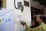 Menteri Badan Usaha Milik Negara (BUMN) Rini Soemarno (kanan) menunjukkan tanda telah tersambungnya listrik saat meninjau rumah warga penerima bantuan sambungan listrik gratis untuk masyarakat tidak mampu melalui Program BUMN Hadir Untuk Negeri di Magetan, Jawa Timur, Jumat (1/2/2019). Pemerintah melalui program tersebut merencanakan penyambungan listrik gratis bagi 128.098 keluarga tidak mampu yang ditargetkan selesai Maret 2019. Antara Jatim/Siswowidodo