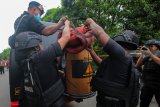 Tim Gegana Satbrimob Polda Jatim memasukkan benda menyerupai granat nanas ke dalam tabung pengaman usai dievakuasi dari dalam sungai dekat Rumah Pompa Dharma Husada, Surabaya, Jawa Timur, Jumat (1/3/2019). Benda yang ditemukan oleh petugas Dinas Pekerjaan Umum Bina Marga dan Pematusan Kota Surabaya itu selanjutnya diamankan Tim Gegana Satbrimob Polda Jatim. Antara Jatim/Didik Suhartono/zk.