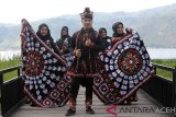 Remaja mengenakan pakaian tradisional motif kerawang gayo sebagai promosi di pesisir pantai danau lut (laut) Tawar, Takengon, Aceh Tengah, Aceh, Jumat (1/3/2019). Kain motif kerawang gayo kini terus berkembang dan menjadi salah satu andalan kostum tadisional dari Provinsi Aceh dan diminati hingga mancanegara. (Antara Aceh/Irwansyah Putra)