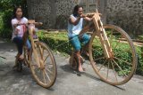 Perajin kayu Sarijo (kanan) bersama anaknya mencoba sepeda kayu buatannya, di Seworagan, Tambakan, Jogonalan, Klaten, Jawa Tengah, Minggu (3/3/219). Sepeda kayu yang memanfaatkan limbah kayu nangka, waru dan mindi itu dijual dengan harga Rp 10 juta - Rp 15 juta tergantung ukuran. (ANTARA FOTO)