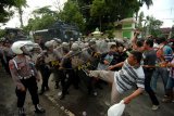 Sejumlah pengunjuk rasa menyerang anggota kepolisian saat simulasi kericuhan pemilu di Alun-alun Hanggawana, Slawi, Kabupaten Tegal, Jawa Tengah, Selasa (5/3/2019). Simulasi kericuhan itu untuk meningkatkan kemampuan dan kesiapan kepolisian dalam menjaga serta mengamankan jalannya pemilu serentak pada 17 April 2019 mendatang. (ANTARA FOTO)