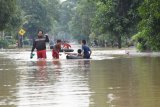 Warga melintasi jalan yang terendam banjir di Desa Simo, Kecamatan Kwadungan, Ngawi, Jawa Timur, Rabu (6/3/2019). Luapan Sungai Madiun yang menggenangi puluhan desa di wilayah itu mengakibatkan sejumlah ruas jalan, ribuan hektare tanaman padi, ratusan rumah terendam, puluhan sekolah SD, MI, SMP, MTs diliburkan. Antara Jatim/Siswowidodo/zk.