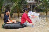 Sejumlah anak bermain sampan dari ban truk di lokasi banjir di Desa Simo, Kecamatan Kwadungan, Ngawi, Jawa Timur, Rabu (6/3/2019). Luapan Sungai Madiun yang menggenangi puluhan desa di wilayah itu mengakibatkan sejumlah ruas jalan, ribuan hektare tanaman padi, ratusan rumah terendam, puluhan sekolah SD, MI, SMP, MTs diliburkan. Antara Jatim/Siswowidodo/zk.