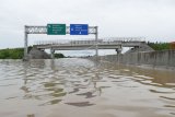 Susasana jalan tol Trans Jawa ruas Ngawi-Kertosono pada KM 603-604 yang terendam banjir di Desa Glonggong, Balerejo, Kabupaten Madiun, Jawa Timur, Kamis (7/3/2019). Luapan Sungai Madiun serta beberapa anak sungainya mengakibatkan sejumlah wilayah di Kabupaten Madiun terendam banjir, dan jalan tol yang terendam tersebut hanya difungsikan satu ruas dengan sistem buka tutup. (ANTARA FOTO)